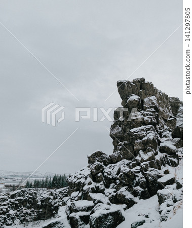 Snow-covered rocky cliffs in Thingvellir National Park, Iceland, during winter. 141297805
