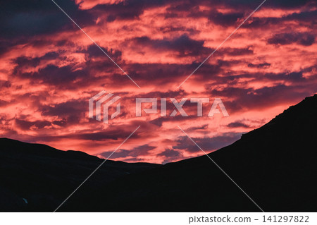 Fiery red and pink clouds during a stunning sunset over Hornafjordur, south Iceland. Fiery red and pink clouds during a stunning sunset over Hornafjordur, south Iceland. 141297822
