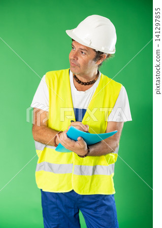 Man in reflective vest and hard hat on green screen background with paper inventory form Man in reflective vest and hard hat on green screen background with paper inventory form 141297855