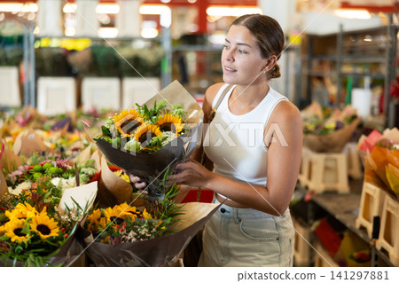 Young woman choosing bouquet of flowers 141297881