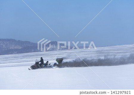 Agricultural scenes of spreading de-icing agents on snow-covered fields in Hokkaido; scenes of farm work as spring approaches. 141297921