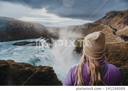 Traveler admiring the powerful Gullfoss waterfall in south Iceland's Golden Circle. Traveler admiring the powerful Gullfoss waterfall in south Iceland's Golden Circle. 141298089