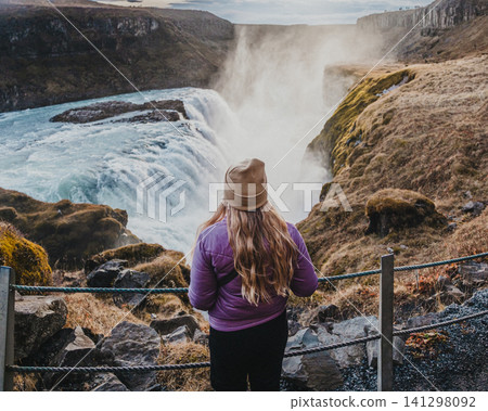 Traveler admiring the powerful Gullfoss waterfall in south Iceland's Golden Circle. Traveler admiring the powerful Gullfoss waterfall in south Iceland's Golden Circle. 141298092