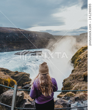 Traveler admiring the powerful Gullfoss waterfall in south Iceland's Golden Circle. Traveler admiring the powerful Gullfoss waterfall in south Iceland's Golden Circle. 141298093