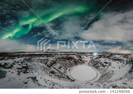Northern lights above the snow-covered Kerid Crater and frozen lake in south Iceland 141298098