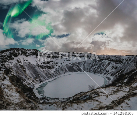 Northern lights above the snow-covered Kerid Crater and frozen lake in south Iceland Northern lights above the snow-covered Kerid Crater and frozen lake in south Iceland 141298103