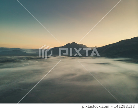 Misty sunrise over Hornafjordur valley with silhouetted mountains, south Iceland. Misty sunrise over Hornafjordur valley with silhouetted mountains, south Iceland. 141298138