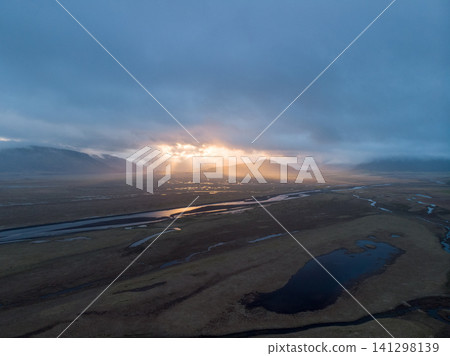 Golden sun rays break through dramatic clouds over Hornafjordur valley, south Iceland. Golden sun rays break through dramatic clouds over Hornafjordur valley, south Iceland. 141298139