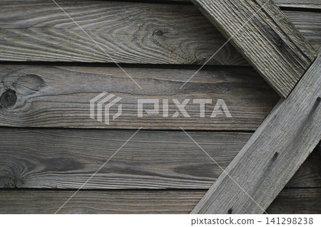 Weathered wooden planks with a diagonal board detail in close up view. Rustic wood texture background for construction, design, furniture and natural material concepts Weathered wooden planks with a diagonal board detail in close up view. Rustic wood texture background for construction, design, furniture and natural material concepts 141298238