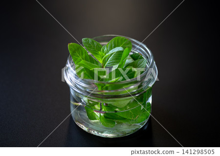 Fresh green mint leaves in glass jar Fresh green mint leaves in glass jar 141298505