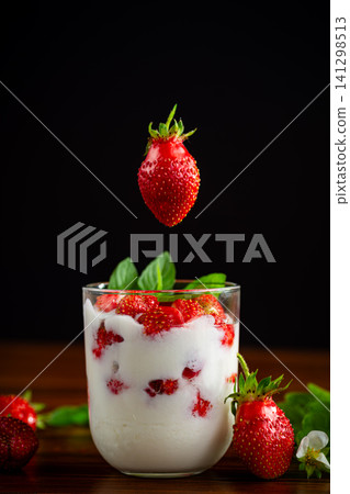 Fresh strawberries with creamy yogurt on wooden table Fresh strawberries with creamy yogurt on wooden table 141298513