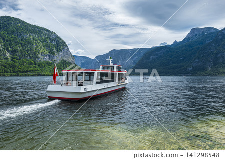Passenger boat cruising on a mountain lake, illustrating a vacation in the Austrian Alps with a scenic summer atmosphere. 141298548