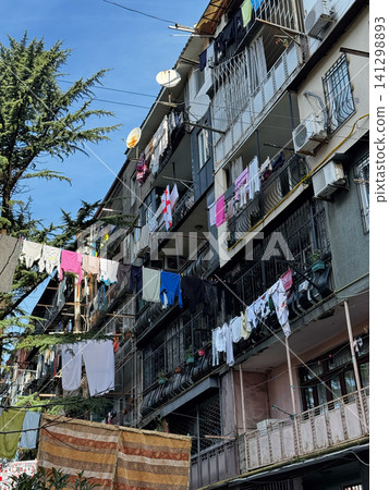 Old apartment building balconies with hanging laundry and Georgian flag in Batumi, Georgia 141298893