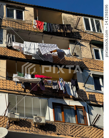 Laundry hanging across old apartment balconies under clear blue sky in Batumi, Georgia Laundry hanging across old apartment balconies under clear blue sky in Batumi, Georgia 141298896