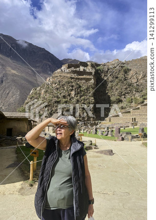 Tourist looking at Ollantaytambo archaeological ruins Tourist looking at Ollantaytambo archaeological ruins 141299113