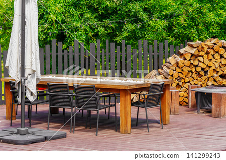 Modern outdoor dining table and chairs on backyard patio terrace, place to relax for group of people Modern outdoor dining table and chairs on backyard patio terrace, place to relax for group of people 141299243