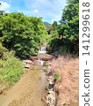 A landscape of a stream with a small waterfall. 141299618