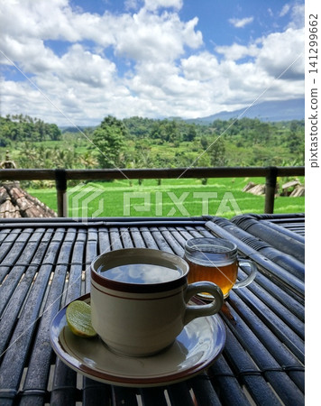 A mug of tea on a beautiful tropical background of rice fields A mug of tea on a beautiful tropical background of rice fields 141299662