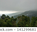 Lush green tropical mountains with a rain cloud at the peak. 141299681