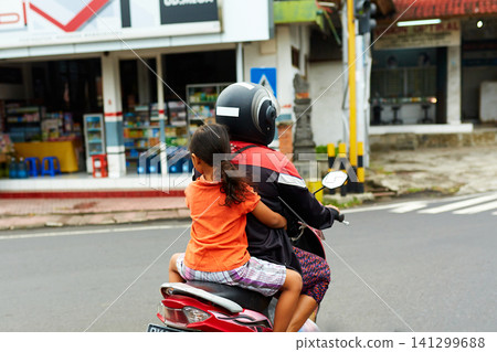 A person on a motorcycle rides a scenic asphalt road in Asia A person on a motorcycle rides a scenic asphalt road in Asia 141299688