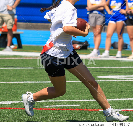 Running With a Football on a Sports Field During a Flag Football Game Running With a Football on a Sports Field During a Flag Football Game 141299907