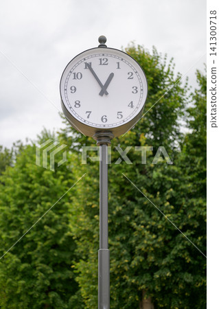 White clock face on tall metal pole White clock face on tall metal pole 141300718