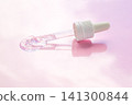Skincare serum dropper with clear gel on pink background for beauty and cosmetic product photography 141300844