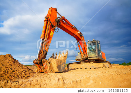 Excavator at construction site. Digger on construction site on blue sky. Excavator at construction site. Digger on construction site on blue sky. 141301125
