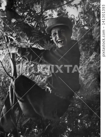 Smiling Soviet Boy Climbing a Tree in Autumn Smiling Soviet Boy Climbing a Tree in Autumn 141301393