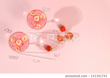 Festive alcoholic cocktail, pink martini in glasses on a bright background with strawberries, summer bar concept, alcoholic drinks at a party, restaurant and cafe advertising, modern still life Festive alcoholic cocktail, pink martini in glasses on a bright background with strawberries, summer bar concept, alcoholic drinks at a party, restaurant and cafe advertising, modern still life 141301741