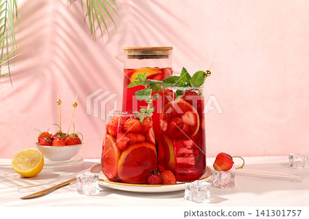 Strawberry Iced Tea or Mint Lemon Cocktail is a refreshing summer drink recipe. Glasses with berry fruit lemonade on a light concrete table, detox diet and weight loss concept, restaurant menu. 141301757