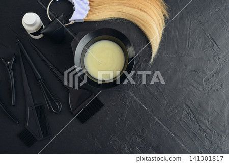 Hair coloring tools arranged on a black textured background. Hair coloring tools arranged on a black textured background. 141301817