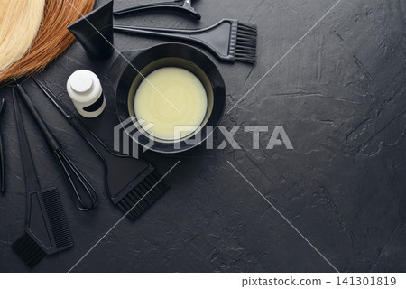 Hair coloring tools arranged on a black textured background. Hair coloring tools arranged on a black textured background. 141301819