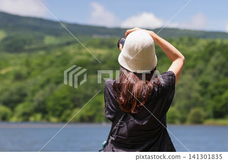 A woman photographs a lake in the highlands at Baraki Lake in Tsumagoi Village, Gunma Prefecture. A woman photographs a lake in the highlands at Baraki Lake in Tsumagoi Village, Gunma Prefecture. 141301835