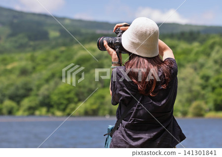 A woman photographs a lake in the highlands at Baraki Lake in Tsumagoi Village, Gunma Prefecture. A woman photographs a lake in the highlands at Baraki Lake in Tsumagoi Village, Gunma Prefecture. 141301841