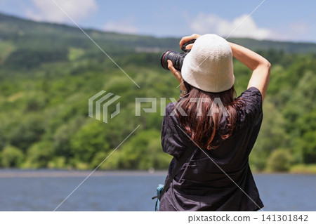 一名女子在群馬縣妻戀村的巴拉基湖高地拍攝湖泊。 一名女子在群馬縣妻戀村的巴拉基湖高地拍攝湖泊。 141301842