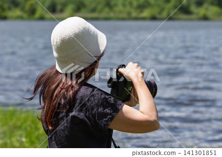 A woman photographs a lake in the highlands at Baraki Lake in Tsumagoi Village, Gunma Prefecture. A woman photographs a lake in the highlands at Baraki Lake in Tsumagoi Village, Gunma Prefecture. 141301851