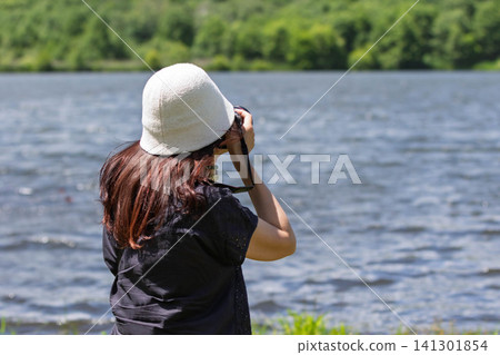 A woman photographs a lake in the highlands at Baraki Lake in Tsumagoi Village, Gunma Prefecture. A woman photographs a lake in the highlands at Baraki Lake in Tsumagoi Village, Gunma Prefecture. 141301854