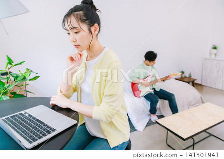 一位職業婦女和一位以彈吉他為愛好的男性。 一位職業婦女和一位以彈吉他為愛好的男性。 141301941