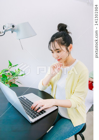 在家使用電腦工作的年輕女性 在家使用電腦工作的年輕女性 141301984