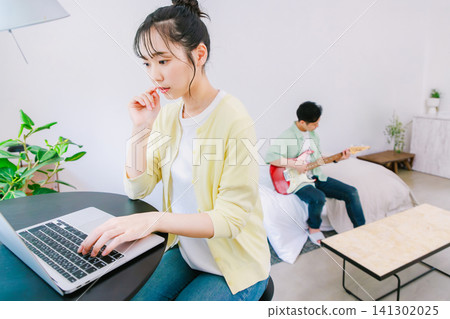 一位職業婦女和一位以彈吉他為愛好的男性。 一位職業婦女和一位以彈吉他為愛好的男性。 141302025