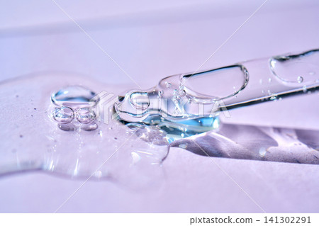 Cosmetic serum liquid flowing from pipette with bubbles 141302291