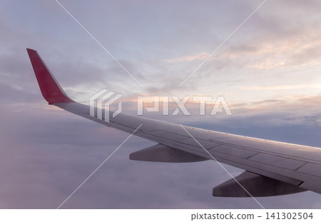 Beautiful salmon dawn and the wing of an airplane above the clouds. Beautiful salmon dawn and the wing of an airplane above the clouds. 141302504