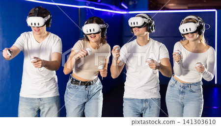 Friends playing video games in virtual reality headsets Friends playing video games in virtual reality headsets 141303610