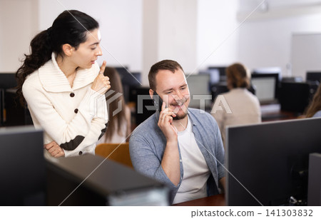 Young woman making remark to man talking on phone Young woman making remark to man talking on phone 141303832