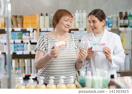 Woman choosing pills with help from pharmacist Woman choosing pills with help from pharmacist 141303925