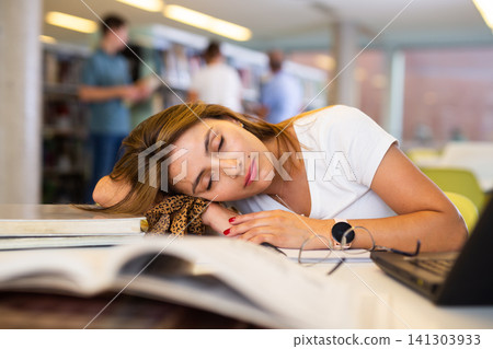 View on tired young Latina female student sleeping View on tired young Latina female student sleeping 141303933