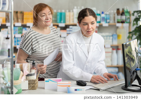 Woman pharmacist looking for prescription on computer for buyer 141303949