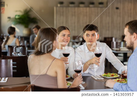 Couples of women and men eating and talking in restaurant Couples of women and men eating and talking in restaurant 141303957