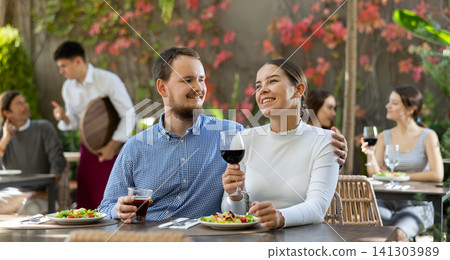 Couple man and woman eating and talking in restaurant Couple man and woman eating and talking in restaurant 141303989